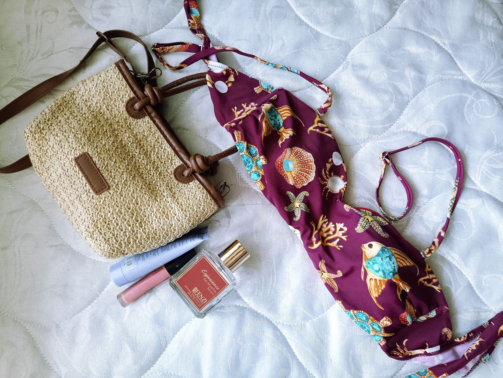 Letni flat lay: bikini, pleciona torba i kosmetyki z filtrem UV