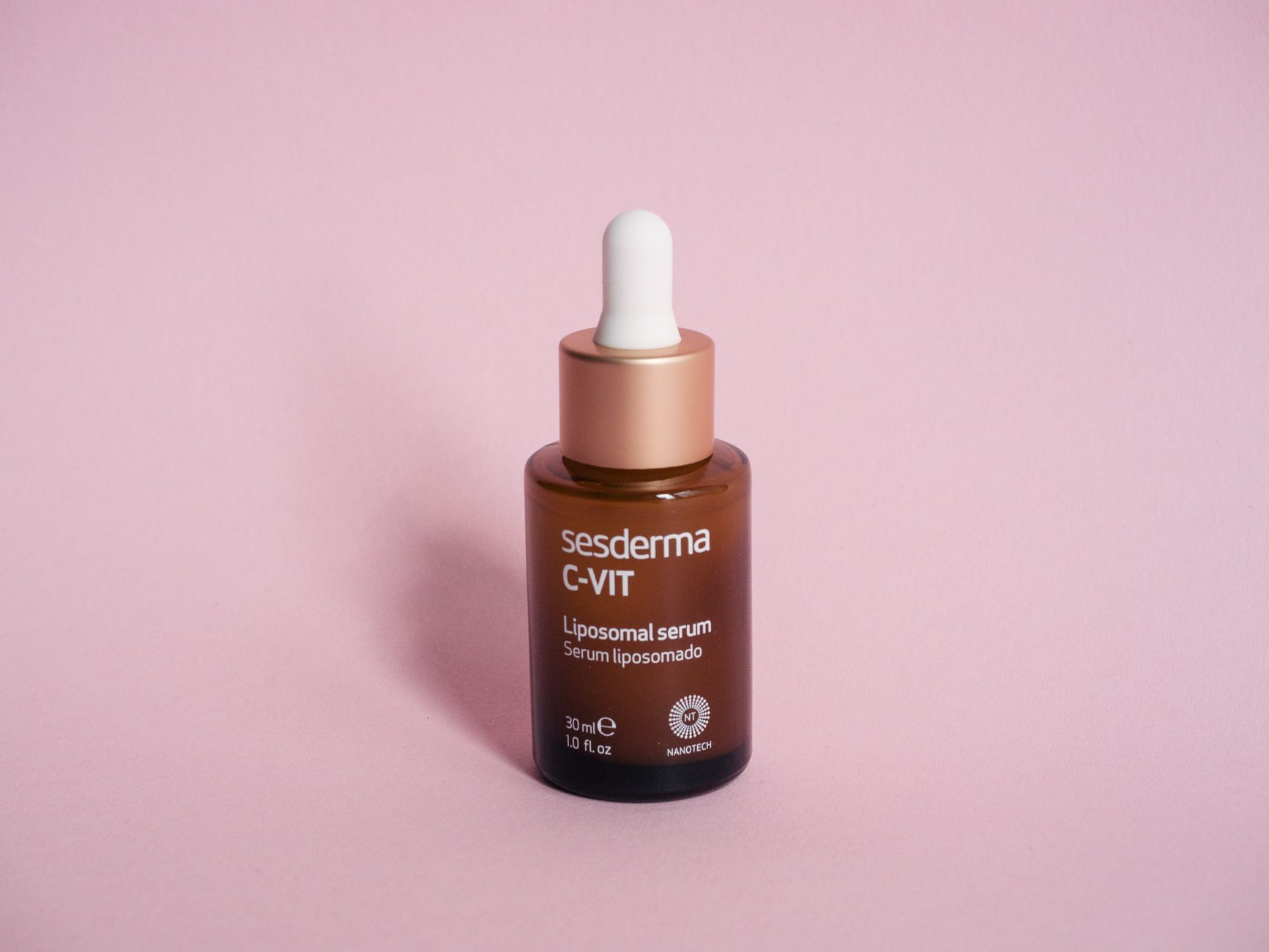 Butelka serum kosmetycznego z pipetą na różowym tle Butelka serum kosmetycznego z pipetą na różowym tle